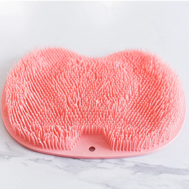 Orange non-slip silicone bath massage mat with suction cups on a bathroom floor.