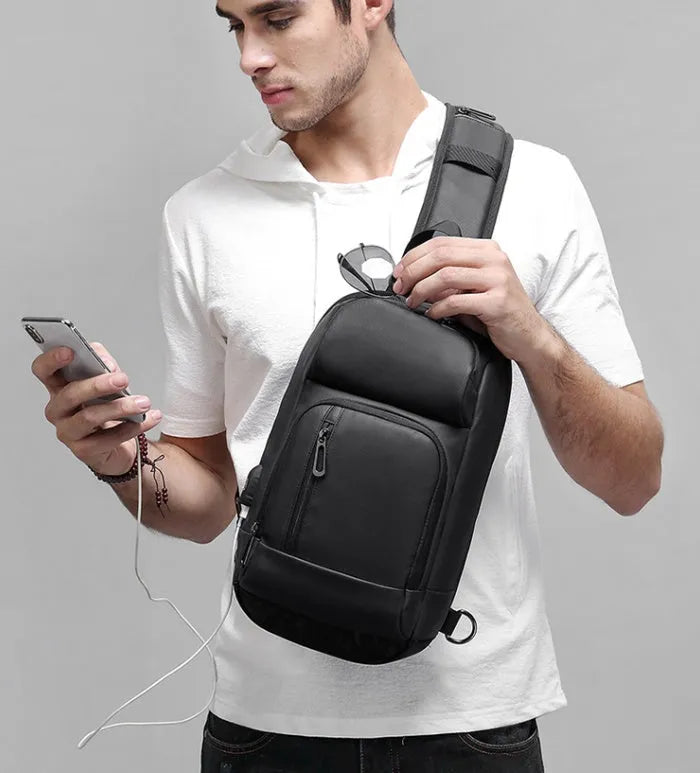 Black medium PVC outdoor shoulder bag showing air cushion strap, soft handle, and internal organiser pockets.