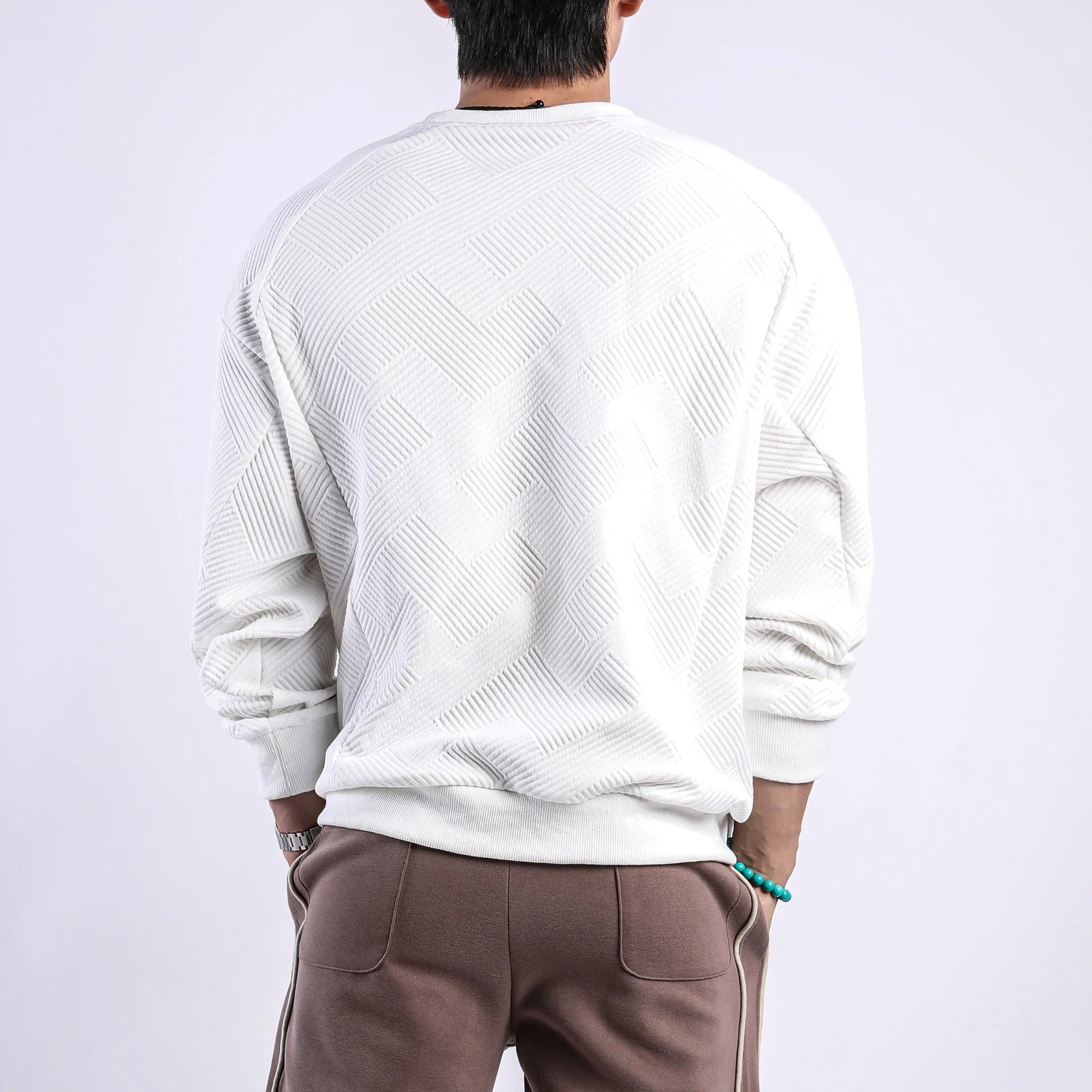 Man wearing a loose fit Army Green twill jacquard long sleeve pullover sweater.