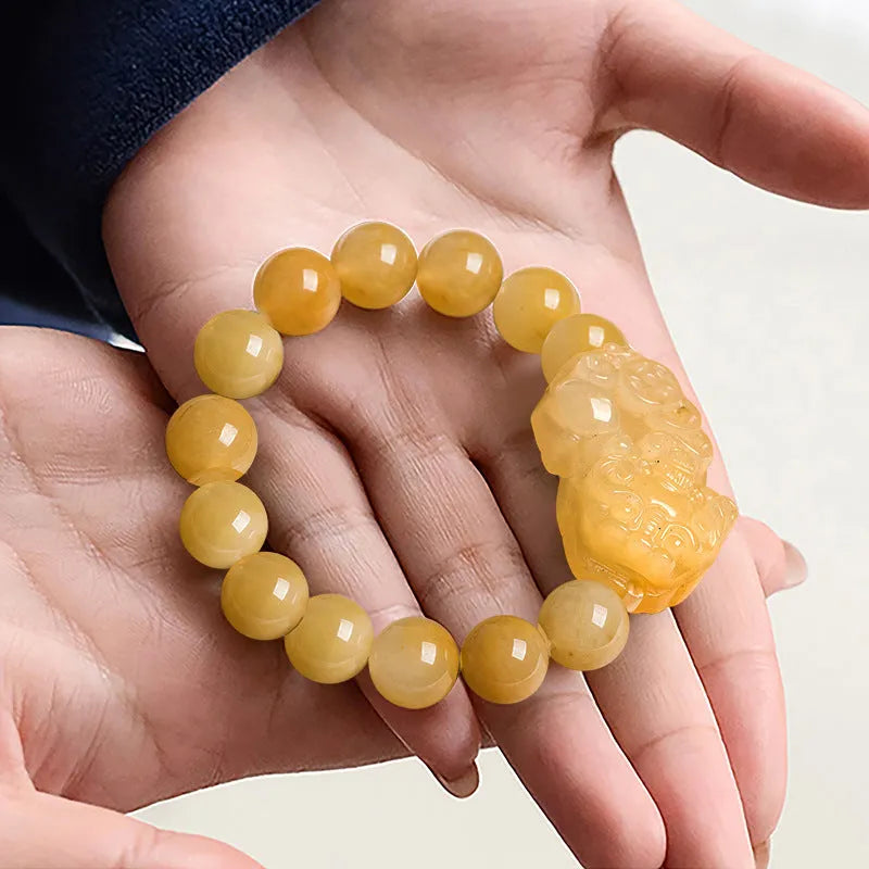 Hand-carved Golden Thread Jinsi Jade money bracelet showing carved detail, offered in large and small unisex sizes.