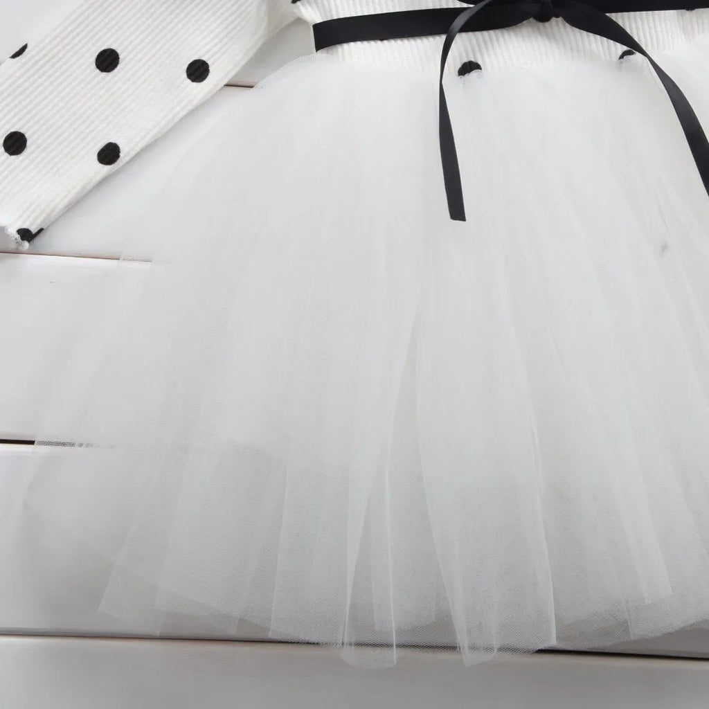 Baby girl wearing a long sleeve black tutu dress with lace detail, suitable for a party or casual wear.