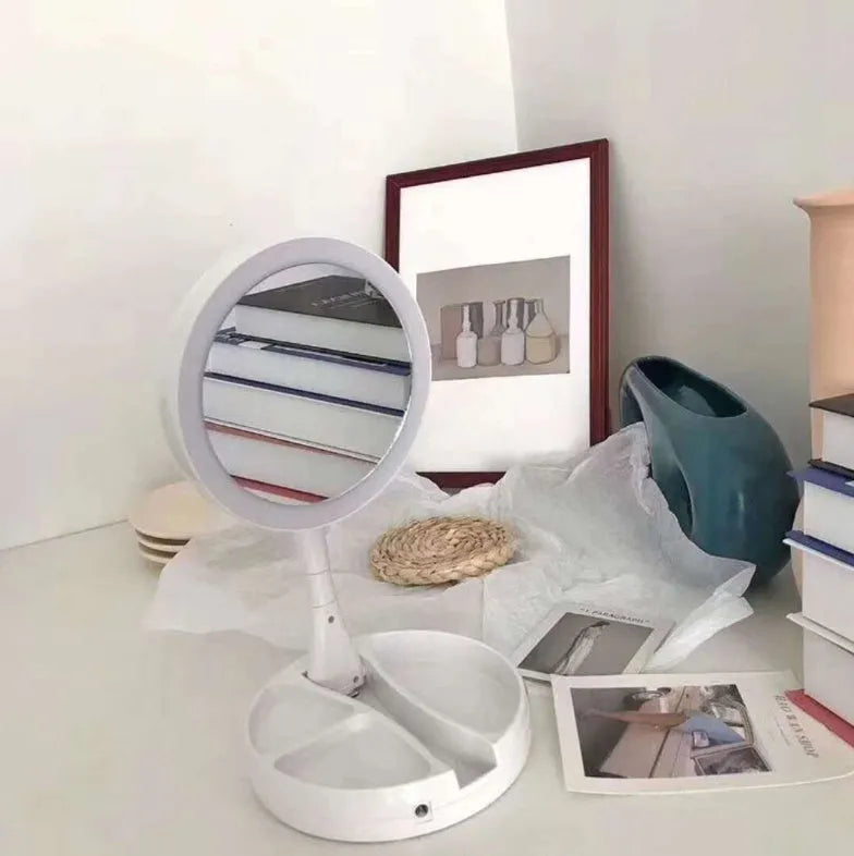 White acrylic double-sided vanity mirror with LED lights and a foldable stand.