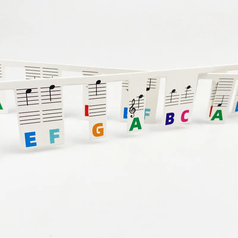 White card piano note bar stickers for 88-key keyboards with colour-coded notes and separate black note bag