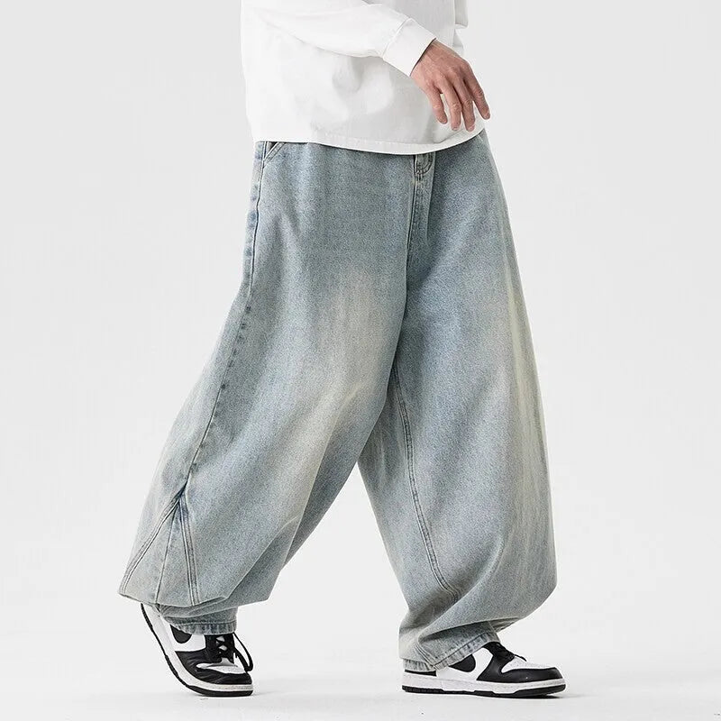 Men's plus size baggy blue jeans with wide straight legs on a hanger.
