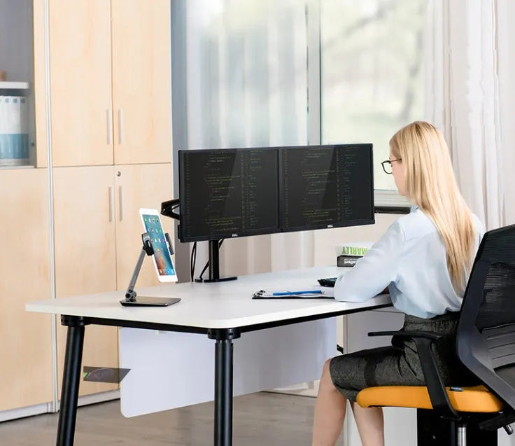 Black foldable aluminium phone and tablet stand with 360-degree rotation on a wooden desk