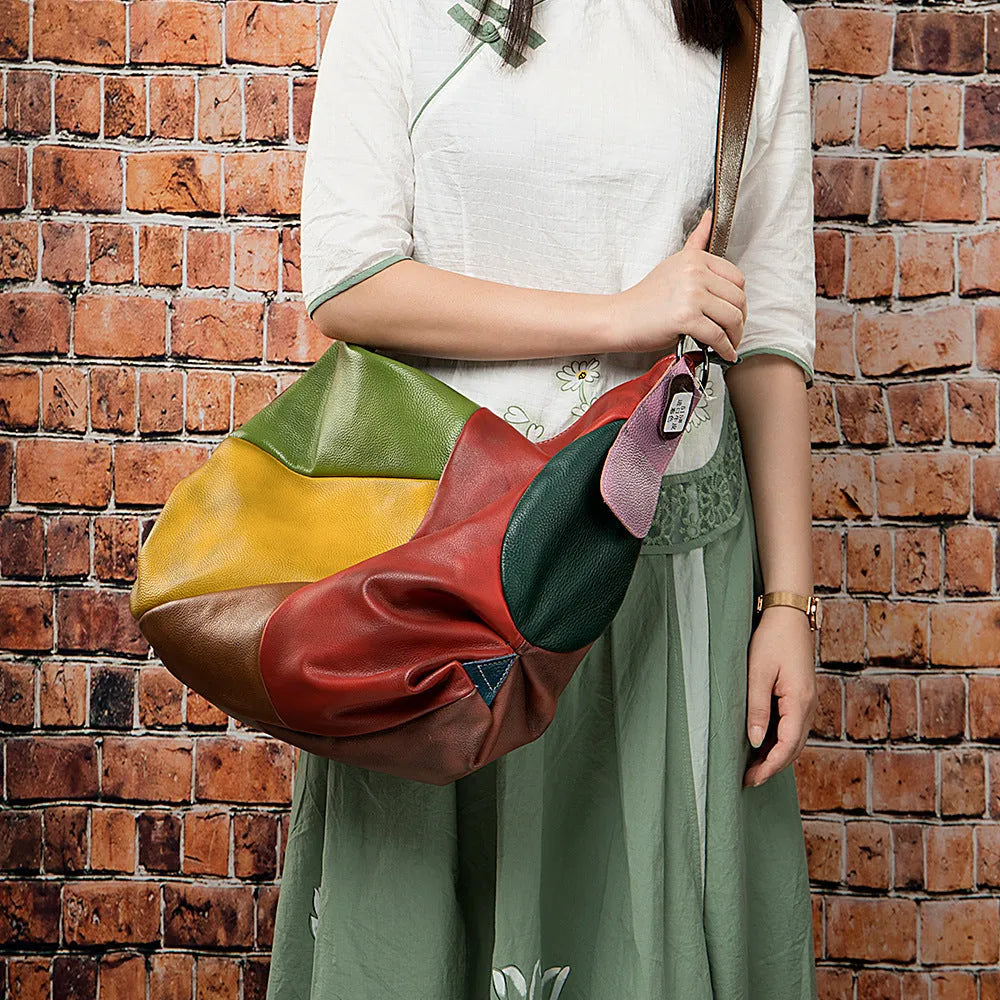 Brown cowhide leather travel bag with stitching detail, shown as a crossbody bag.
