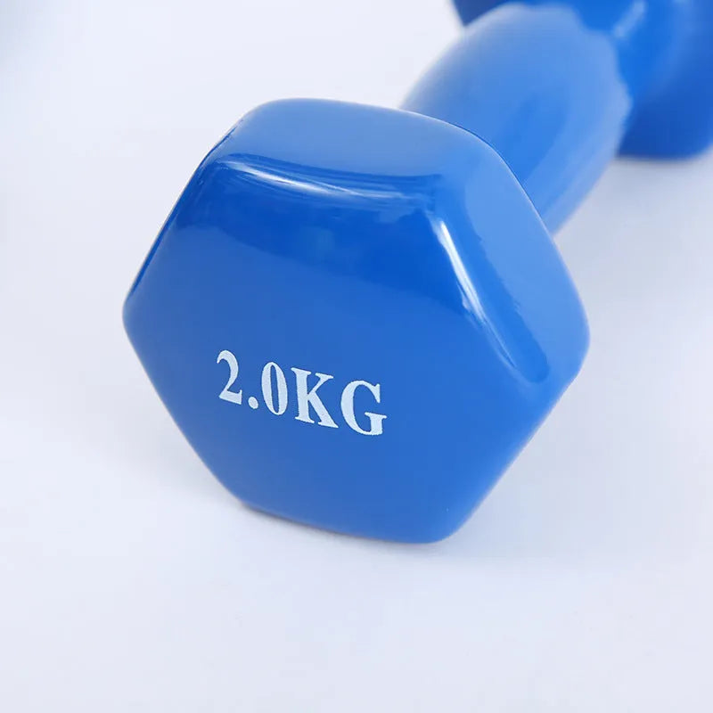 Bright coloured plastic-coated fitness dumbbell showing glossy finish on a home gym floor.