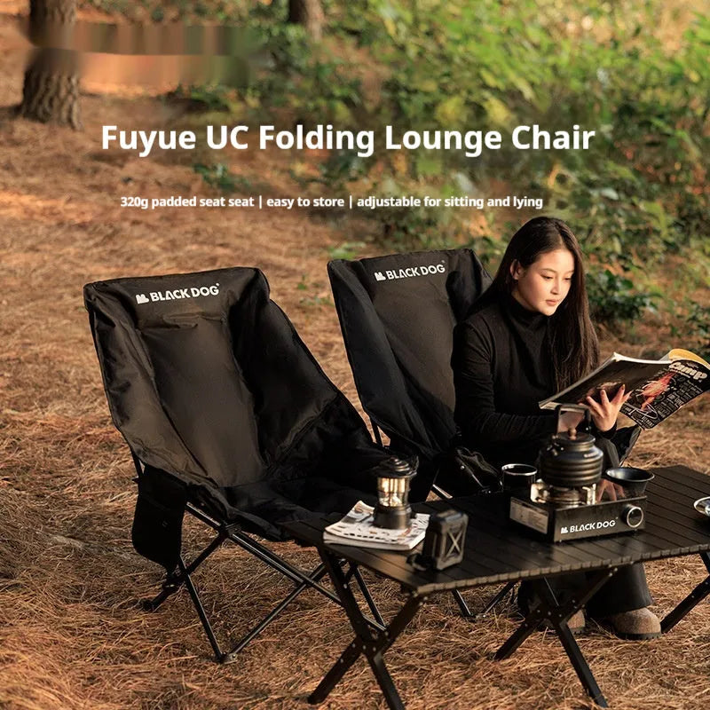 Night Black Oxford cloth folding moon chair in a reclined position on grass.