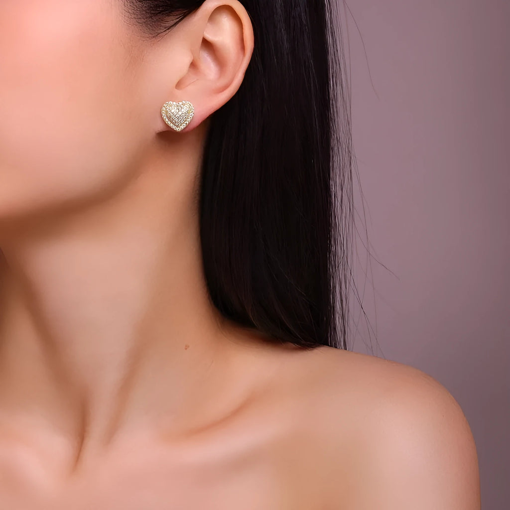 A pair of gold-coloured heart-shaped moissanite stud earrings on S925 silver posts.