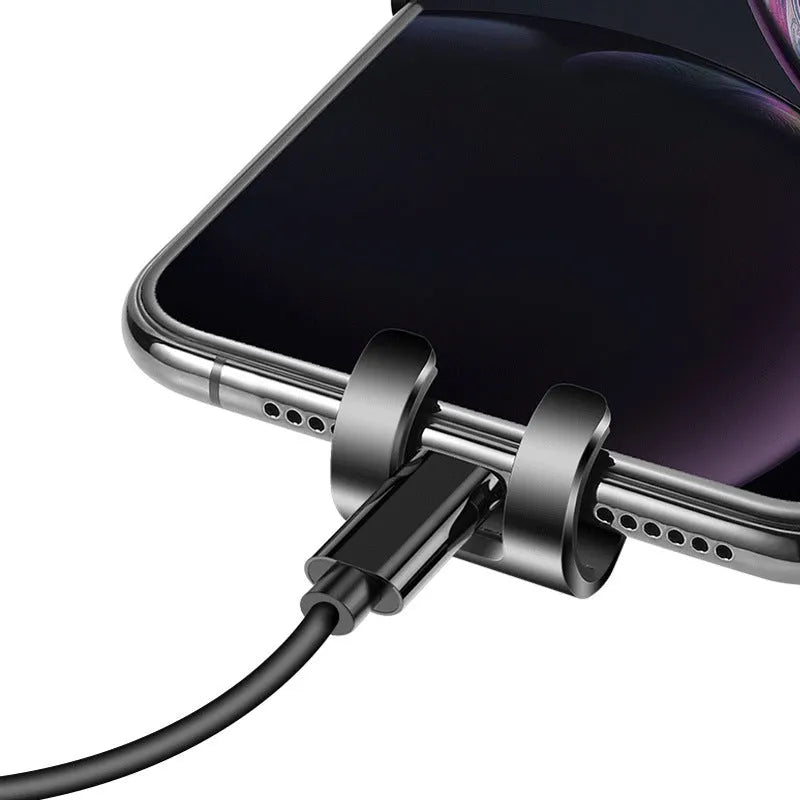 Black S4 gravity mobile phone bracket clipped onto a car air conditioning vent, holding a smartphone.
