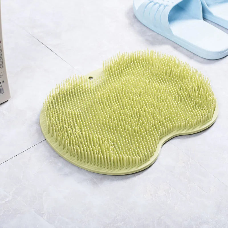 Orange non-slip silicone bath massage mat with suction cups on a bathroom floor.