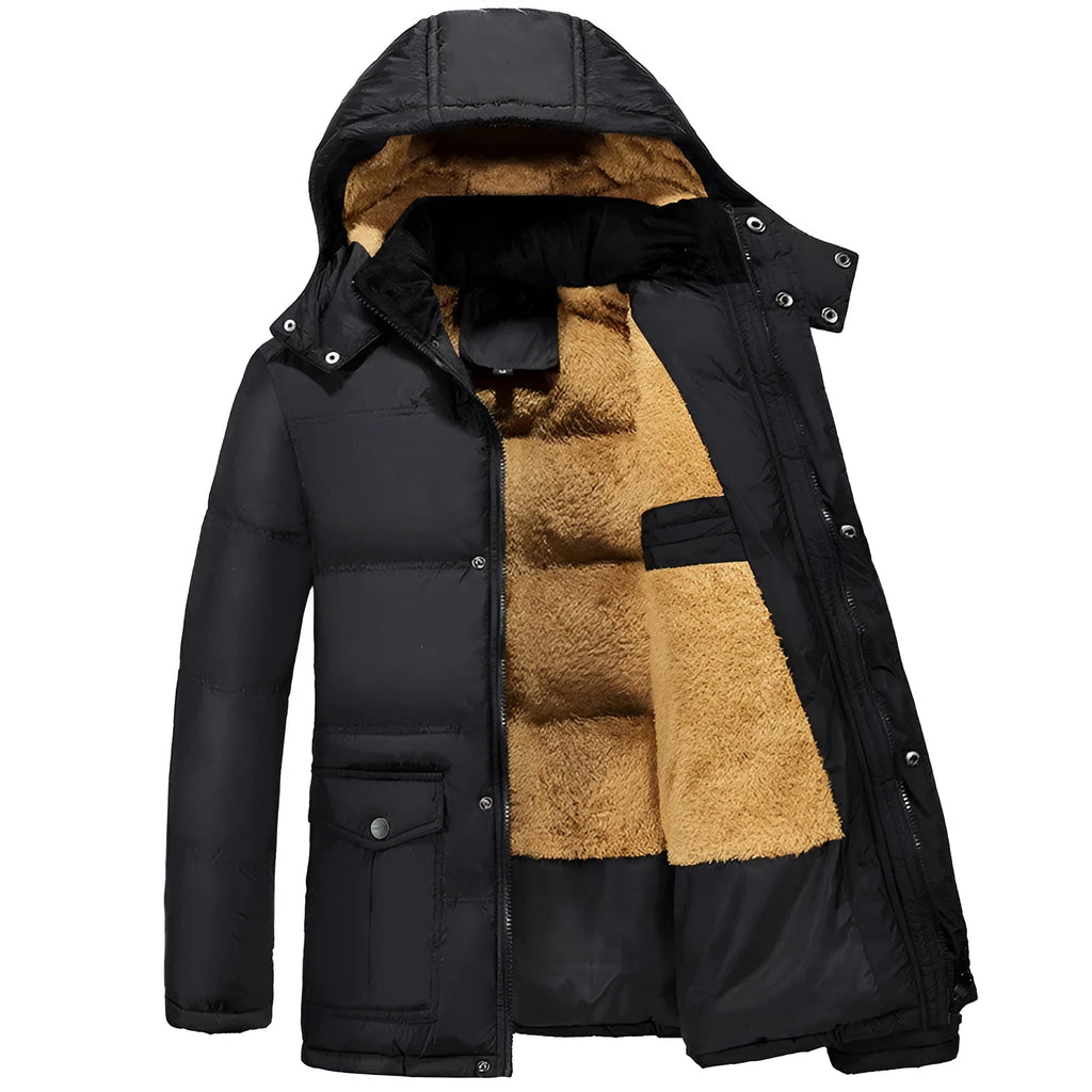 Man wearing a black loose-fit velvet padded jacket with a hood and double-breasted front.