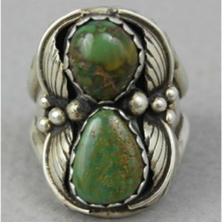Close-up of a women's geometric retro ring with an inlaid turquoise stone on an alloy band.