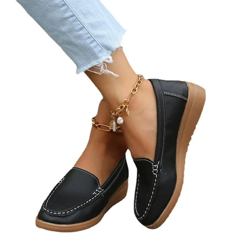 Women's flat loafers in PU leather with car-suture detail on a white background