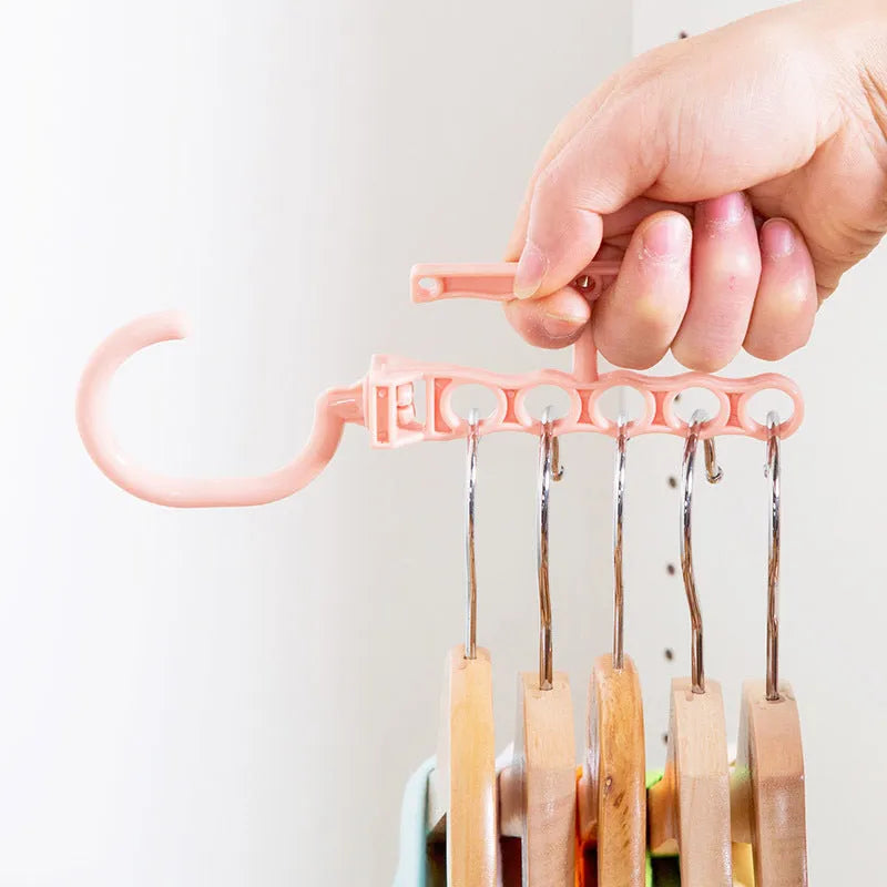 Blue revolving plastic wardrobe hanger with five hooks and a central handle for rotating.