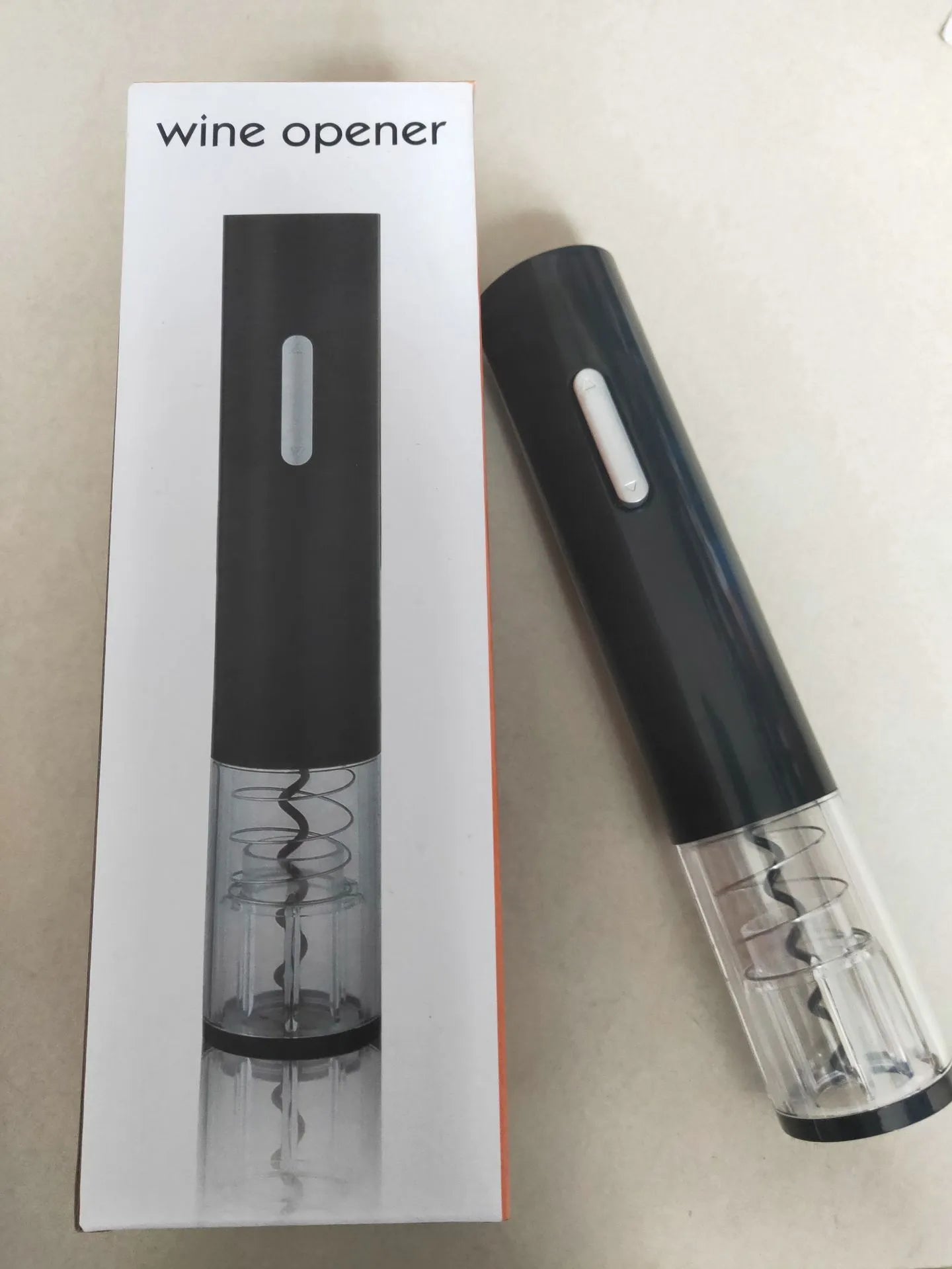 Black automatic electric wine bottle opener with integrated foil cutter on a countertop