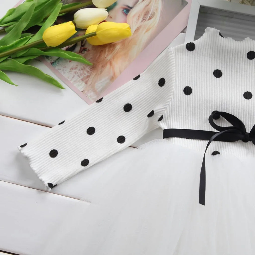 Baby girl wearing a long sleeve black tutu dress with lace detail, suitable for a party or casual wear.