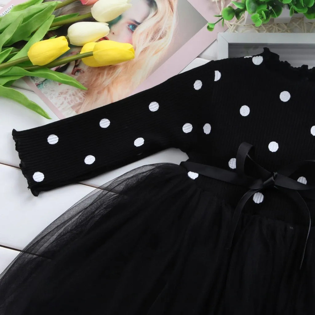 Baby girl wearing a long sleeve black tutu dress with lace detail, suitable for a party or casual wear.
