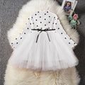 Baby girl wearing a long sleeve black tutu dress with lace detail, suitable for a party or casual wear.