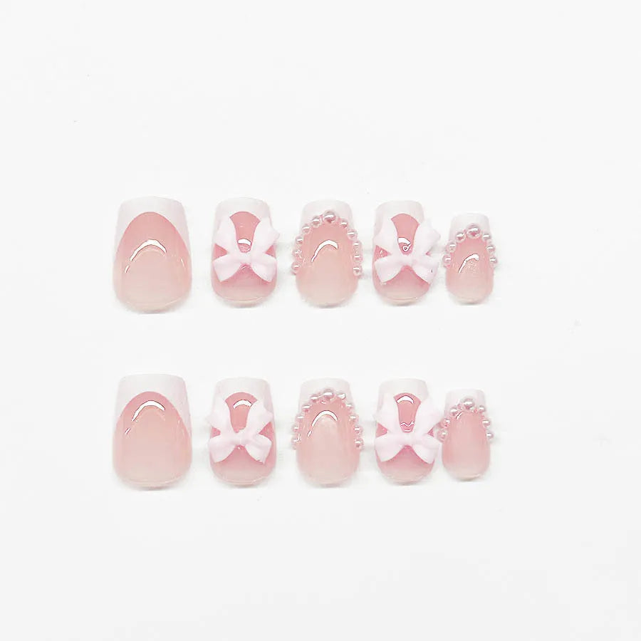 Artificial fashion nail set with white French tips, bow designs, and multiple patterns including tulip and starry sky