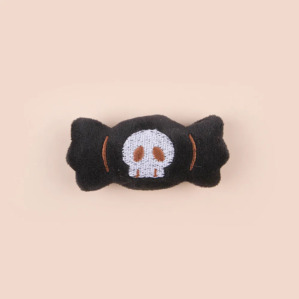 Small plush cat teaser wand with three interchangeable attachments: candy, eyes and skull designs