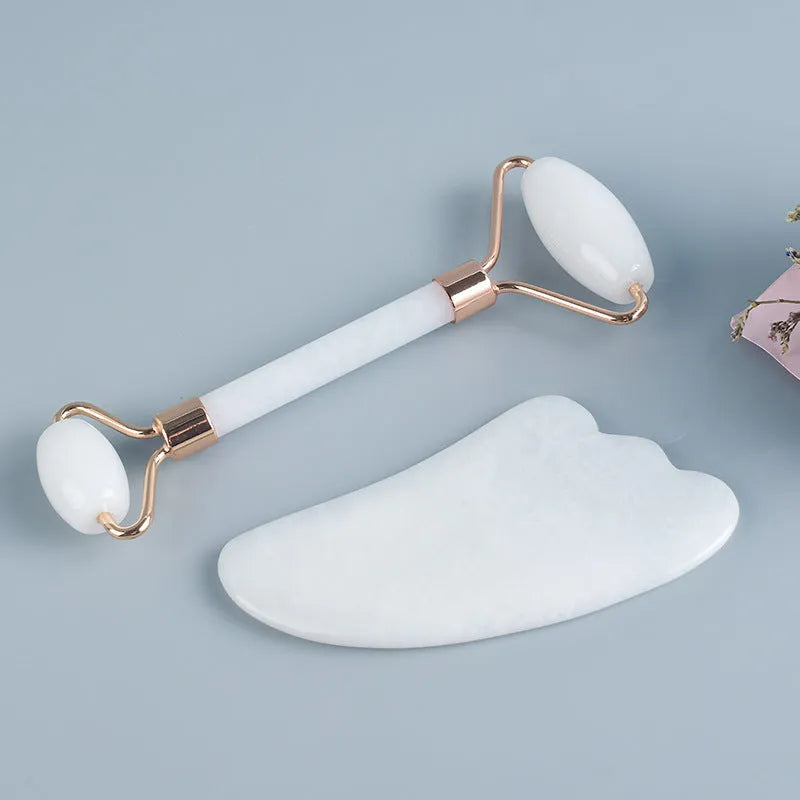 White jade facial roller and matching massage board set on a flat surface.