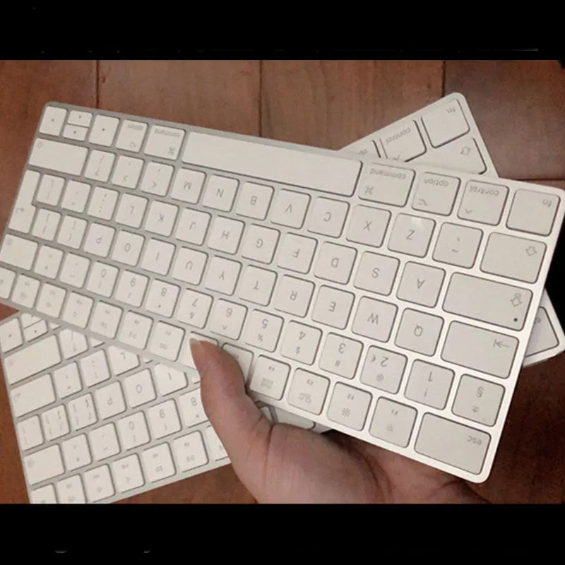 White Apple Bluetooth G6 wireless keyboard with multimedia keys in a metal box.