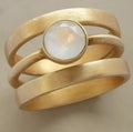 Gold-plated geometric ring with hollow construction and micro-inlaid white chalcedony detailing
