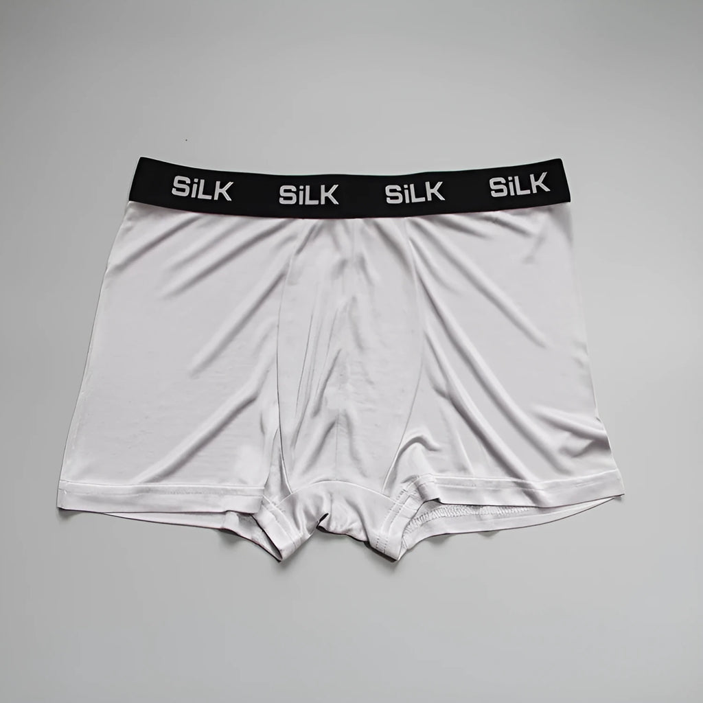 Man wearing loose fit silk shorts in navy blue colour for casual summer wear.
