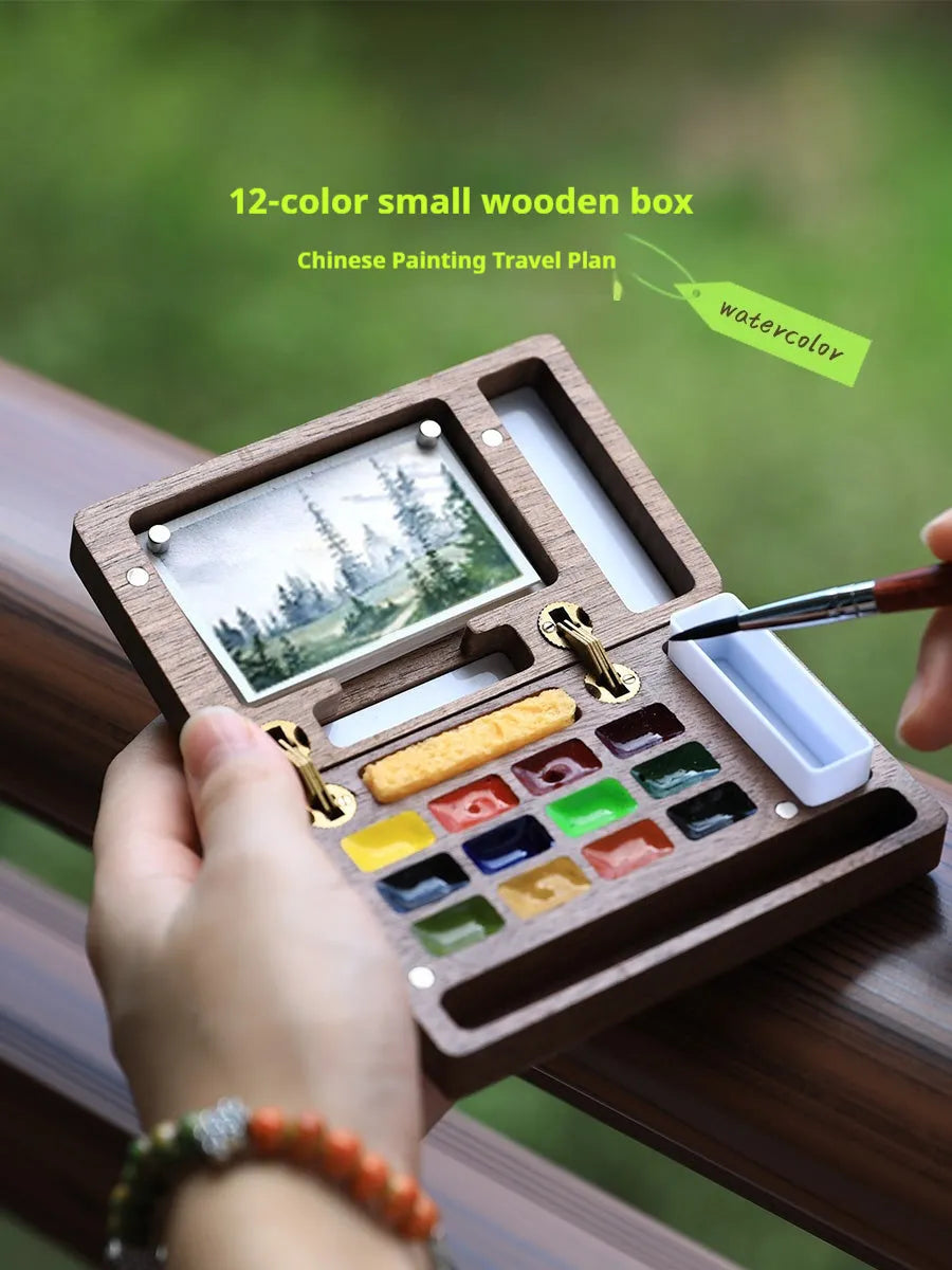 Mini walnut wood watercolour paint box open to show pigment suit selection
