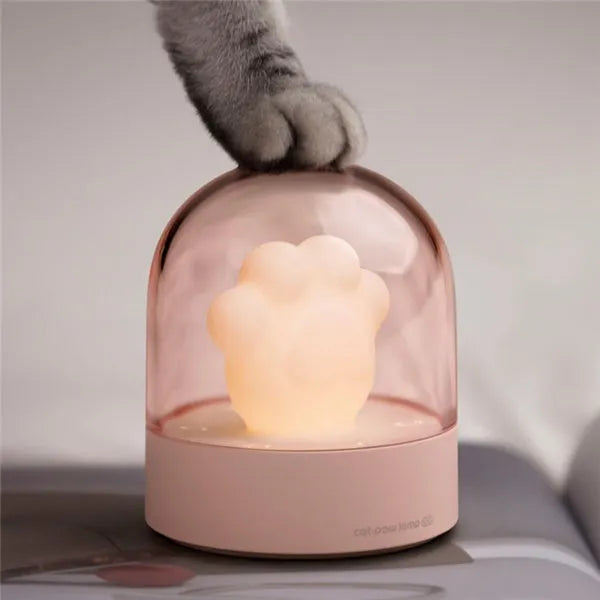 Pink cat paw shaped USB rechargeable night light with musical box function on wooden desktop
