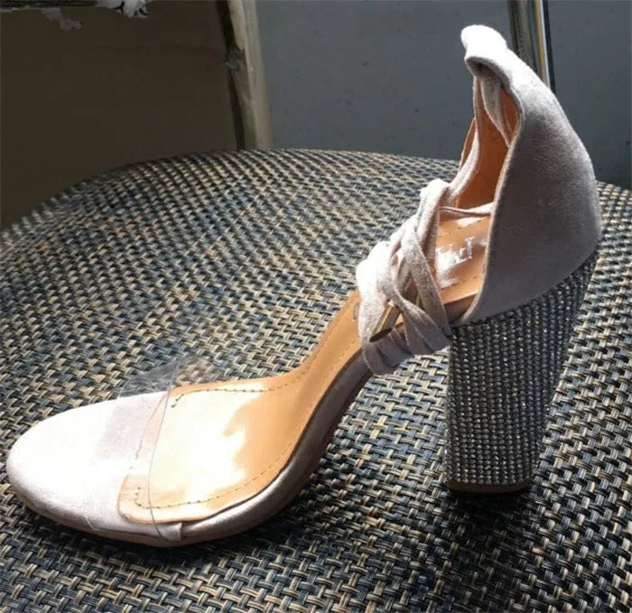 Black and gold plastic high heels with pointed toe design on size display