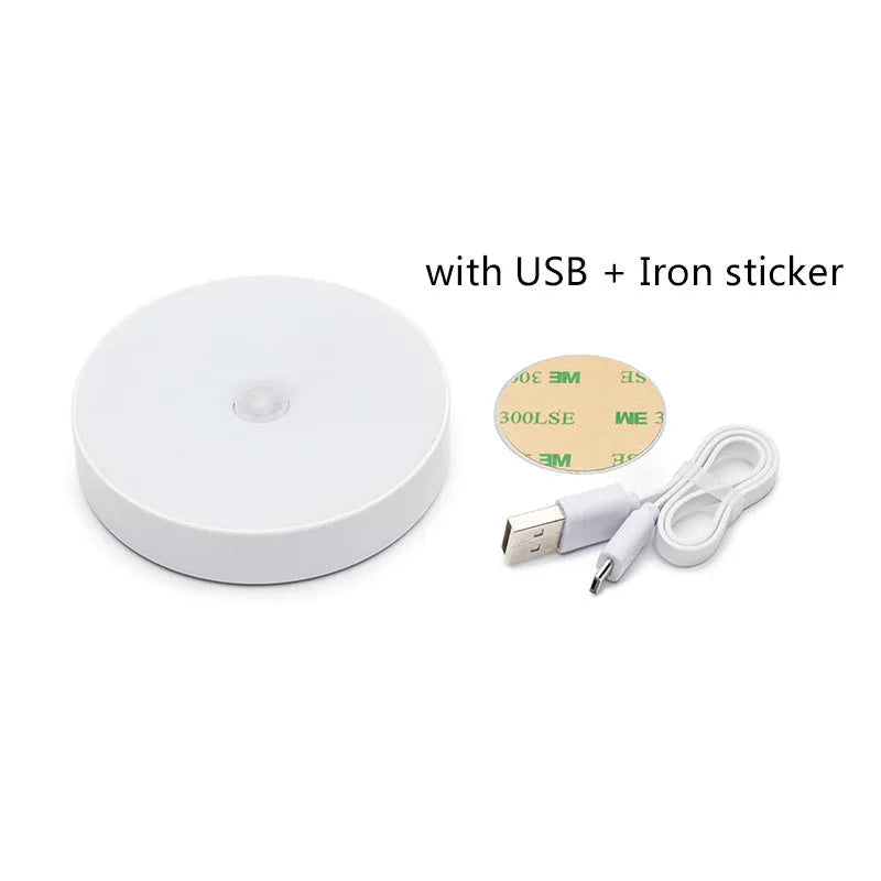 Small white circular USB rechargeable LED motion sensing night light with adhesive backing.