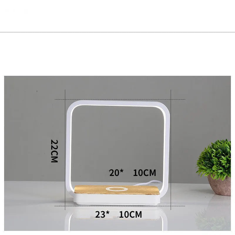 White modern smart bedside lamp with touch sensor and voice control on a wooden table.