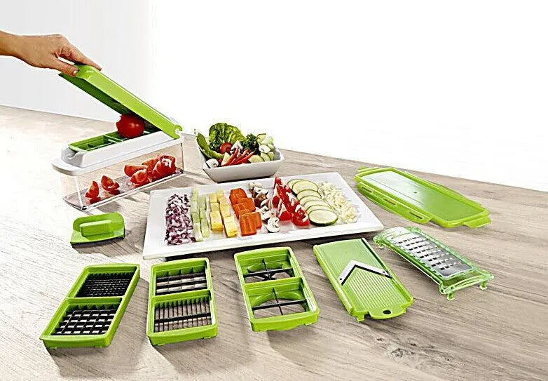 Green manual food chopper with stainless steel blades and plastic body on a kitchen worktop.