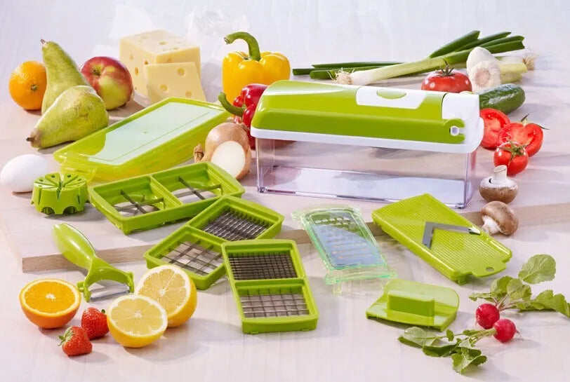 Green manual food chopper with stainless steel blades and plastic body on a kitchen worktop.
