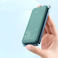 Mint green MagSafe magnetic wireless power bank with back clip, showing compact size next to an iPhone for scale.