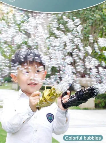 A child holding a pink battery-powered bubble gun toy with a trigger, blowing streams of bubbles outdoors.