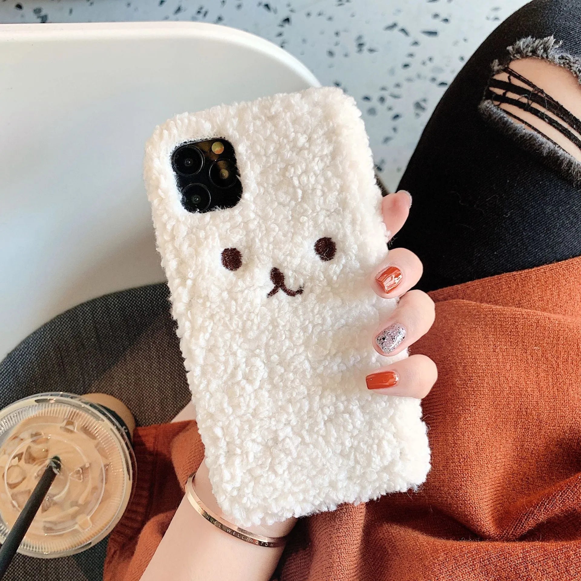 Brown embroidered plush cartoon bear face on a soft TPU iPhone phone case.