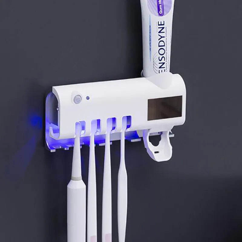 Black and white intelligent UV toothbrush steriliser with automatic toothpaste squeezer mounted on a bathroom wall.