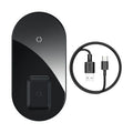 Baseus minimalist two-in-one wireless charger and power bank in black, on a desk charging a phone.