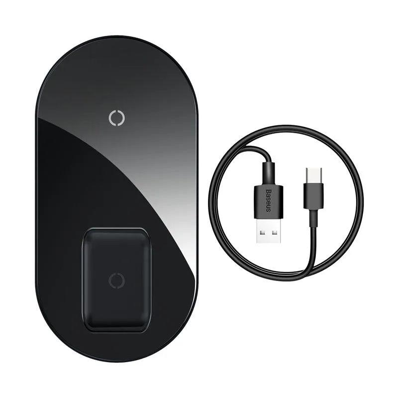 Baseus minimalist two-in-one wireless charger and power bank in black, on a desk charging a phone.