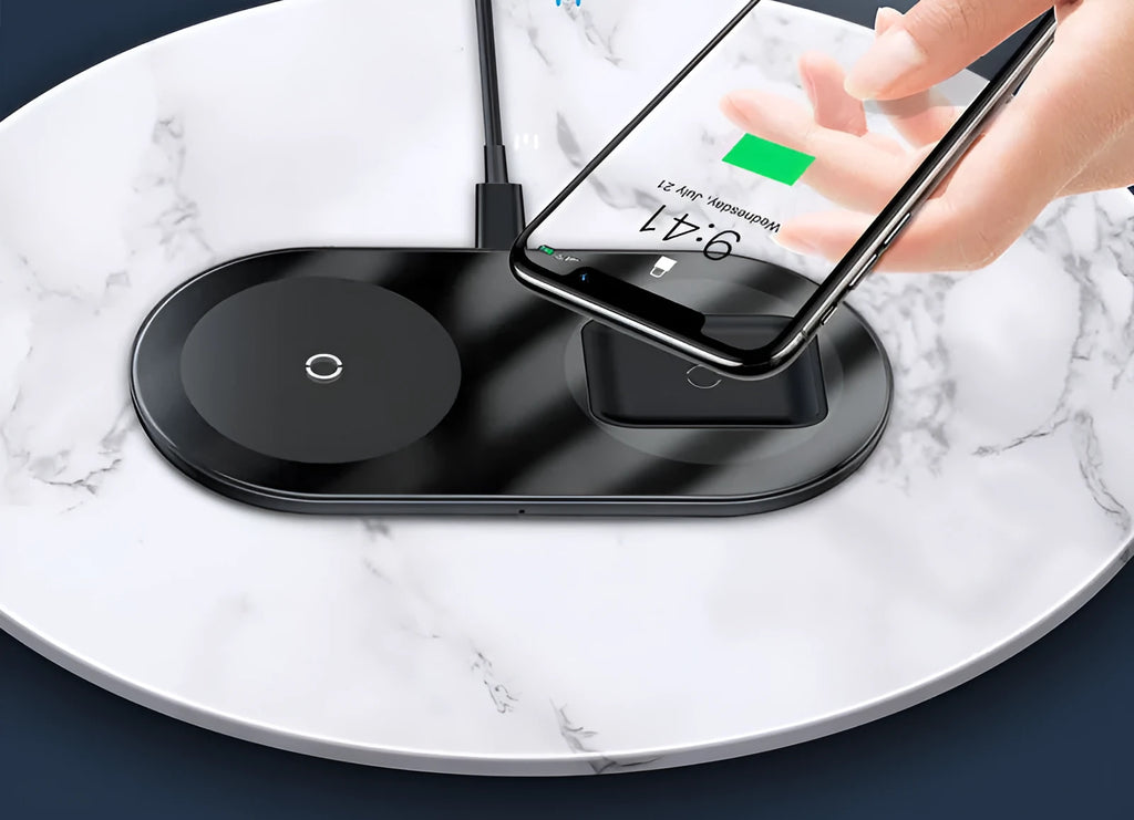 Baseus minimalist two-in-one wireless charger and power bank in black, on a desk charging a phone.