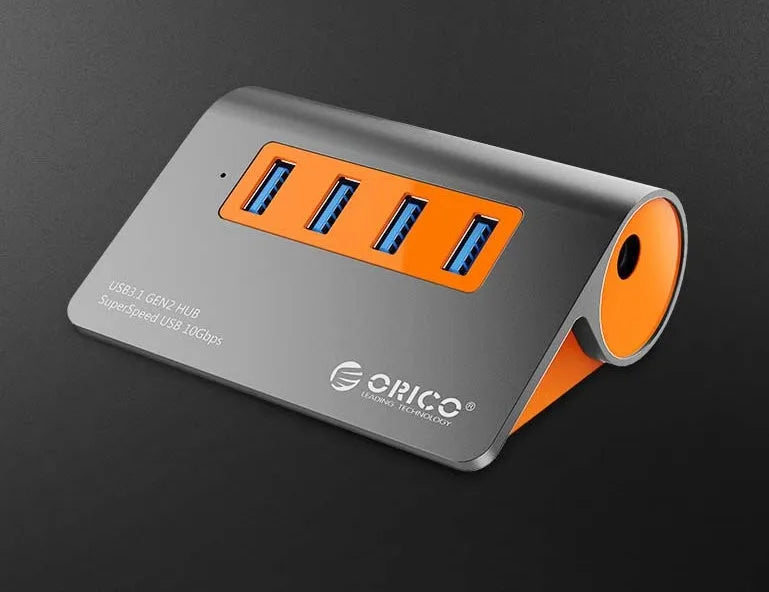 Dark grey and orange aluminium USB-C laptop docking hub with four USB 3.1 ports and a detachable data cable