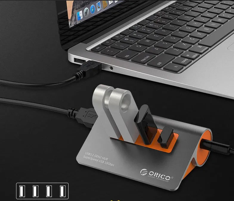 Dark grey and orange aluminium USB-C laptop docking hub with four USB 3.1 ports and a detachable data cable