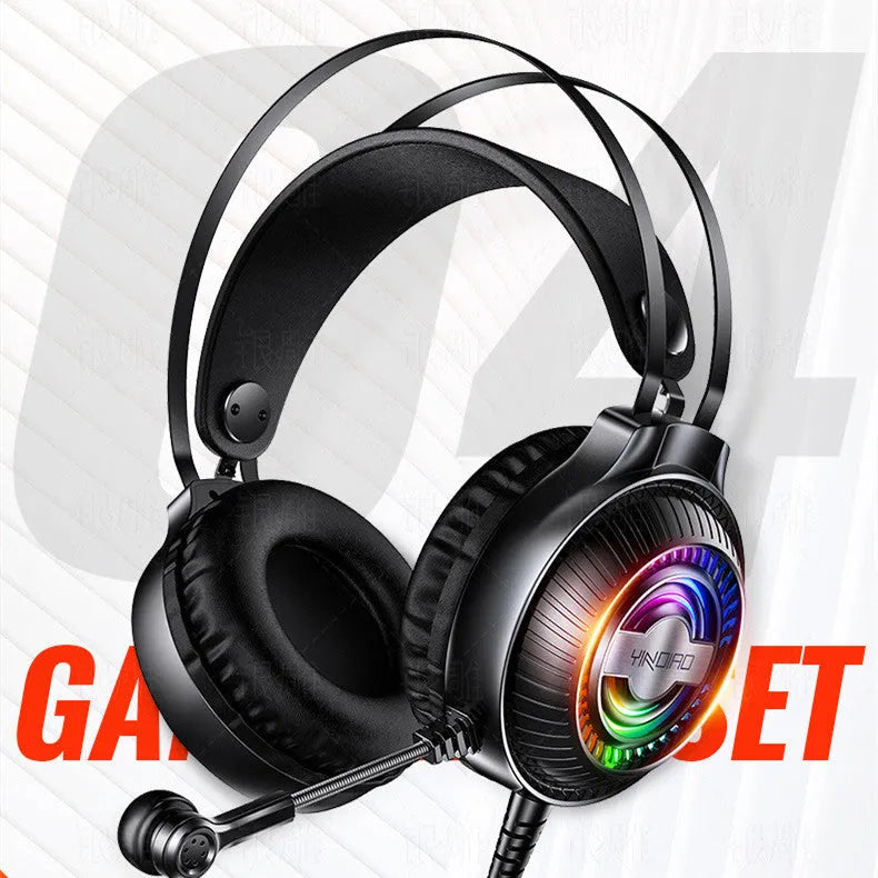 Black and white wired over-ear computer headset with microphone on a desk next to a laptop.