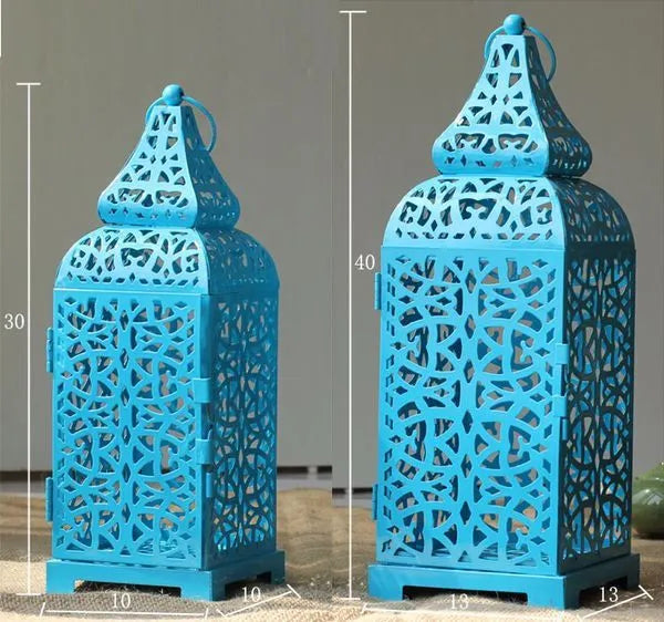 Blue geometric Moroccan style metal lantern candlestick holder on a table.