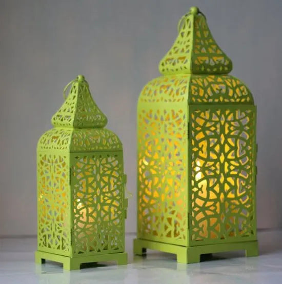 Blue geometric Moroccan style metal lantern candlestick holder on a table.