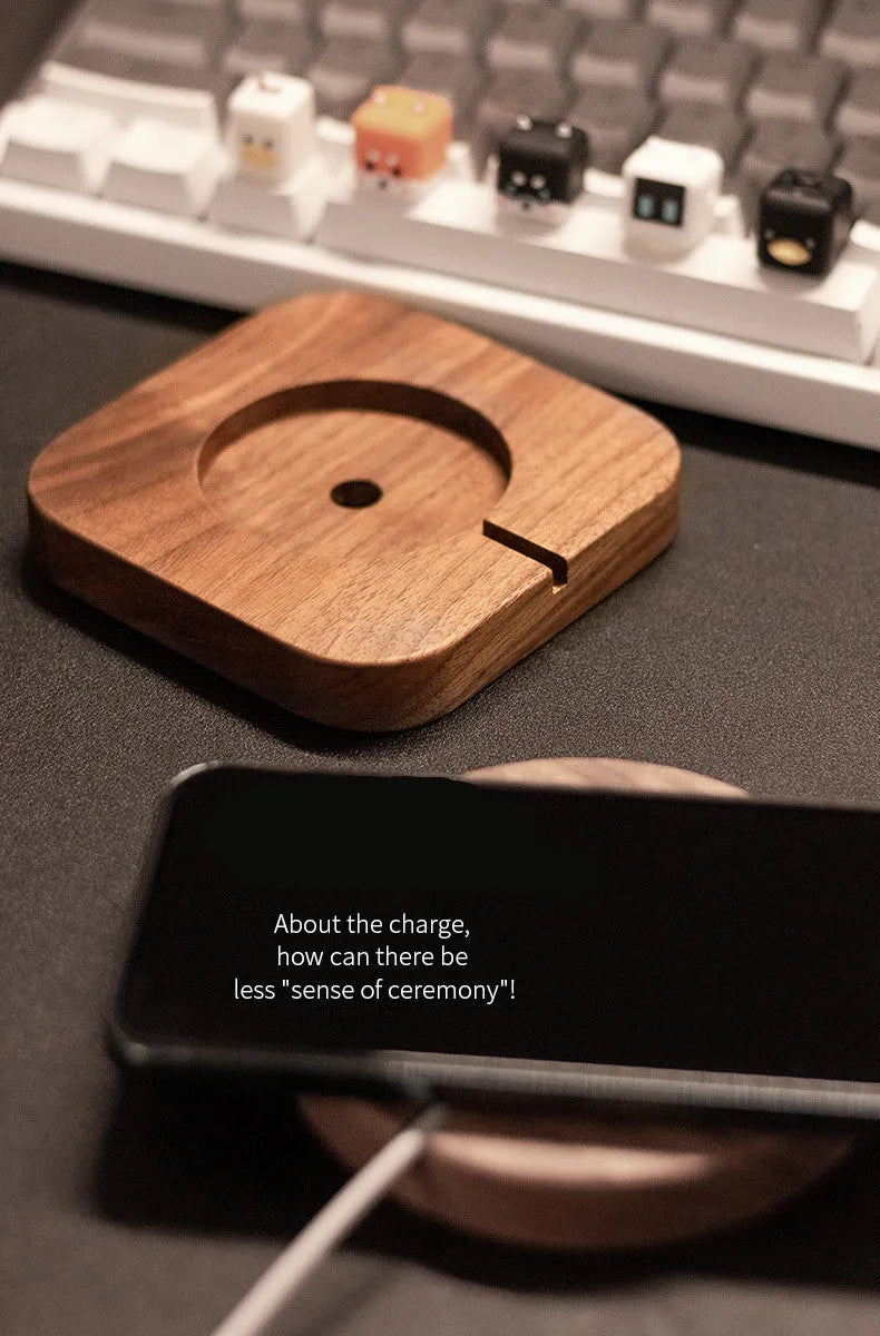 Walnut wood magnetic wireless charging base for MagSafe iPhones on a desk.