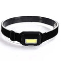 Outdoor mini COB LED headlight in black colour on adjustable polyester strap.